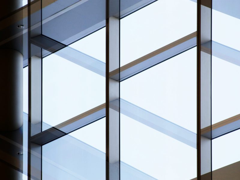 Detalj av en modern glasfasad med eleganta och geometriska linjer, som skapar en känsla av öppenhet och ljusinsläpp